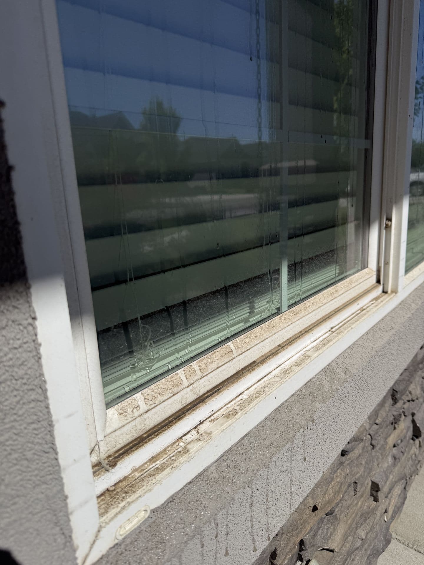 Dirt-caked window sill and streaky glass before detailing